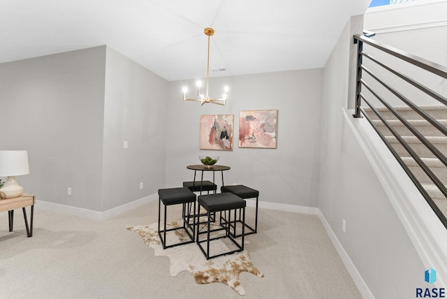 carpeted dining area featuring a chandelier