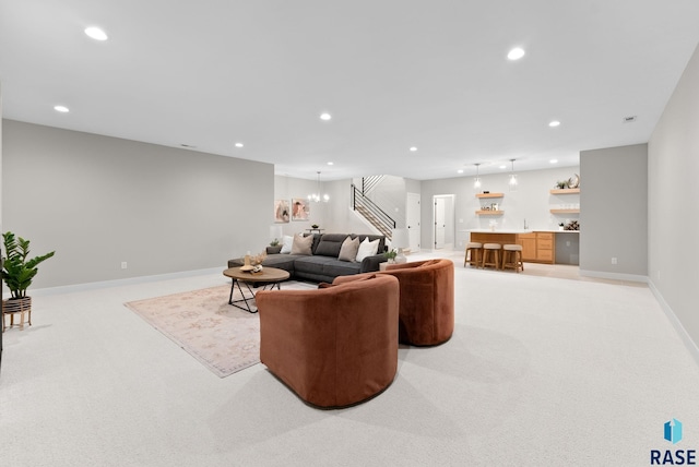 carpeted living room with a chandelier