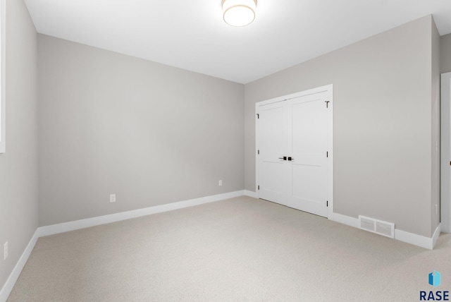 unfurnished bedroom featuring carpet and a closet