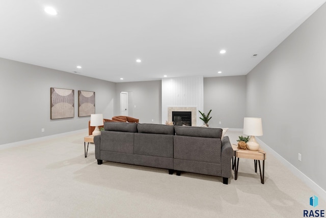 carpeted living room with a large fireplace