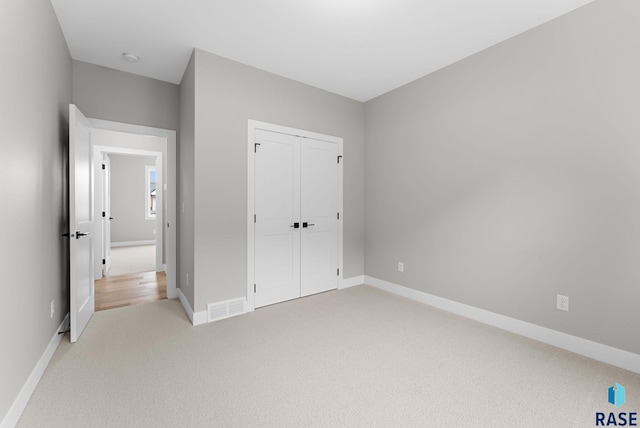 unfurnished bedroom featuring carpet floors and a closet