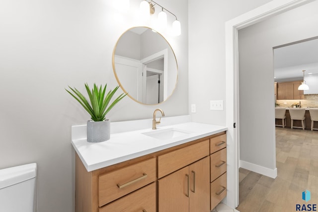 bathroom featuring decorative backsplash, vanity, wood-type flooring, and toilet