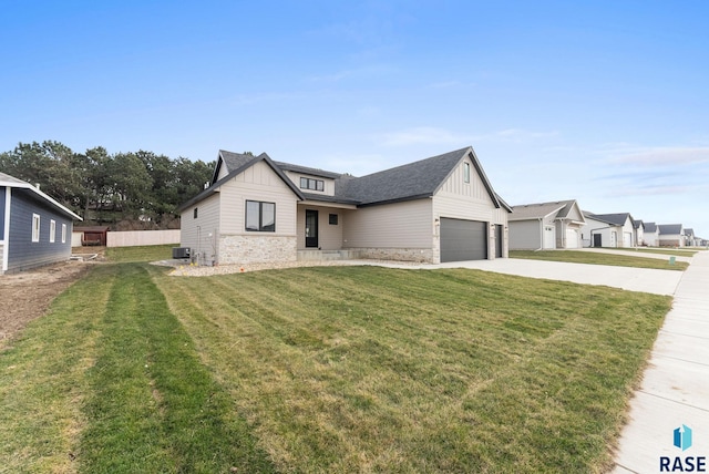 view of front of home featuring cooling unit, a garage, and a front yard