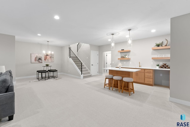 kitchen featuring light carpet, a breakfast bar, a kitchen island, and decorative light fixtures