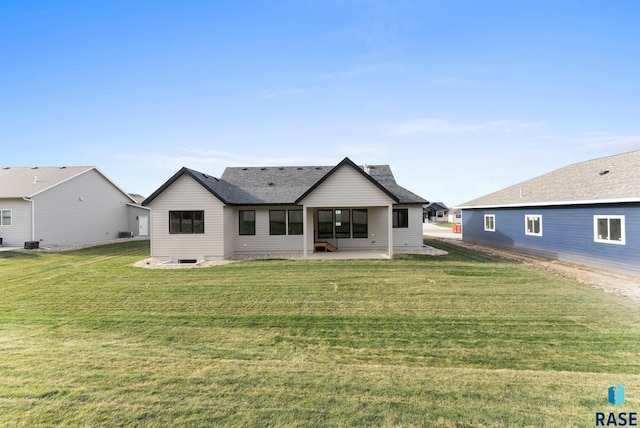 back of property with a lawn and a patio area