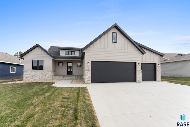 modern inspired farmhouse with a front yard and a garage