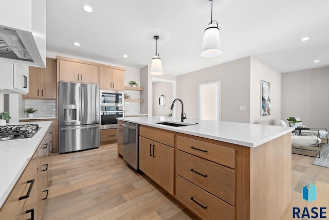 kitchen with decorative backsplash, stainless steel appliances, sink, pendant lighting, and a center island with sink