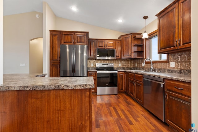 kitchen with decorative backsplash, stainless steel appliances, vaulted ceiling, sink, and pendant lighting