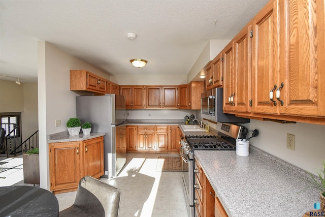 kitchen featuring sink, a textured ceiling, and appliances with stainless steel finishes