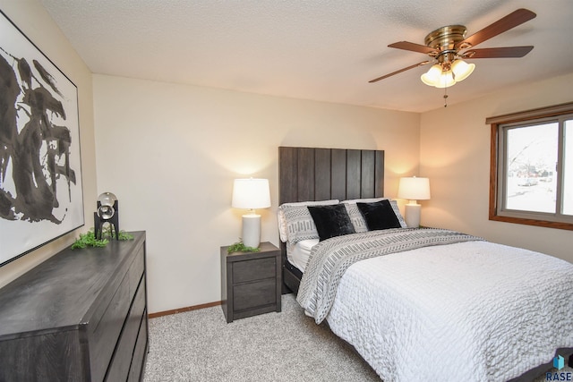 carpeted bedroom featuring a textured ceiling and ceiling fan