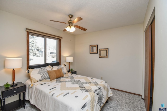 carpeted bedroom with ceiling fan and a closet