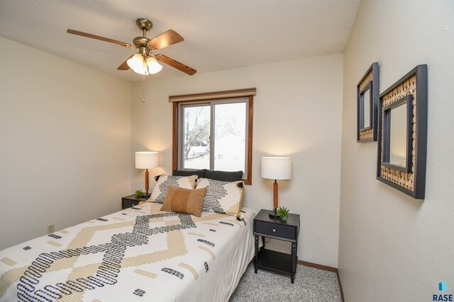 carpeted bedroom with a textured ceiling and ceiling fan