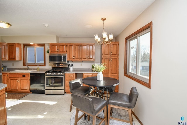 kitchen featuring a chandelier, decorative light fixtures, stainless steel appliances, and sink