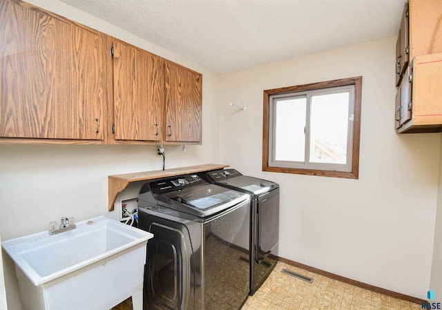 laundry room featuring cabinets, independent washer and dryer, and sink