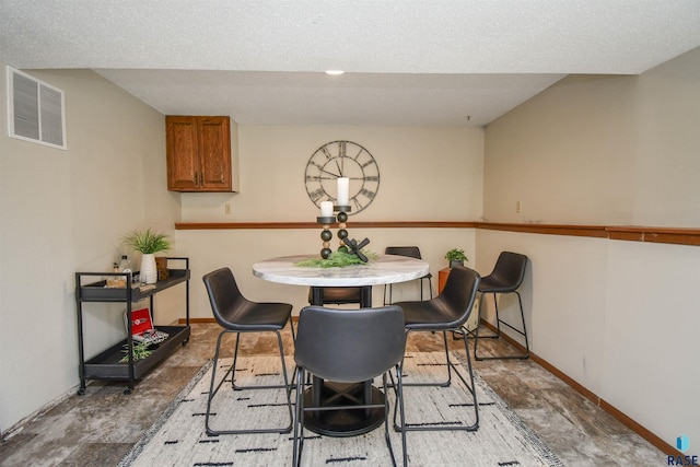 dining space featuring a textured ceiling