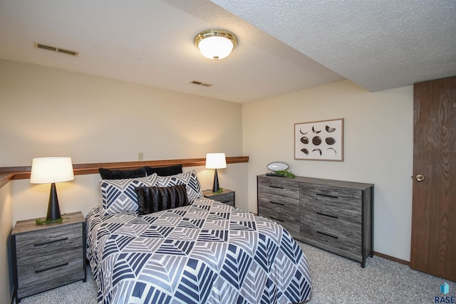 bedroom with a textured ceiling and light colored carpet