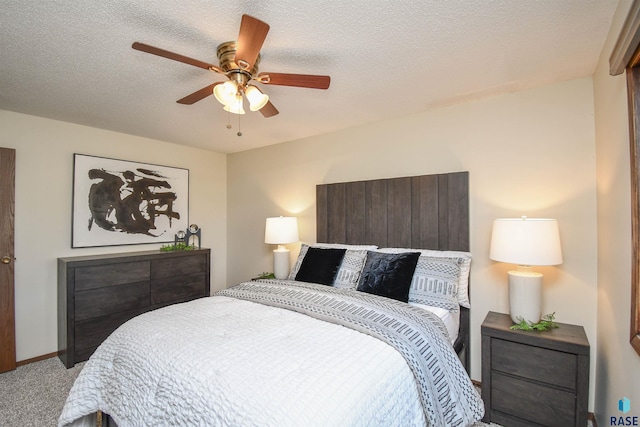 carpeted bedroom featuring ceiling fan and a textured ceiling