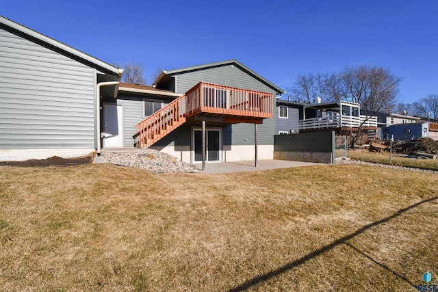 back of property with a yard, a patio area, and a wooden deck