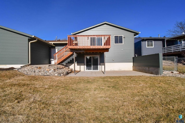 rear view of house featuring a lawn, a patio, and a wooden deck