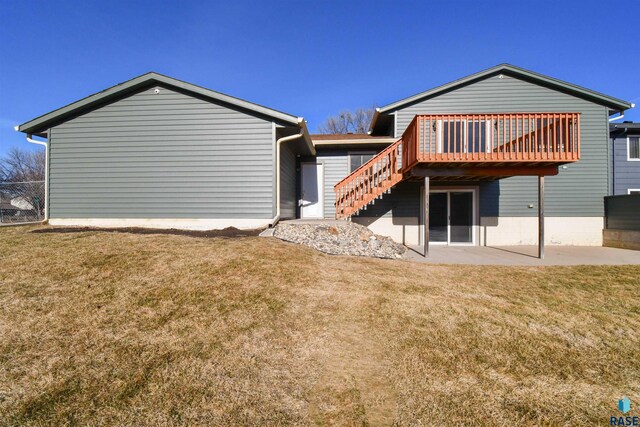 back of house featuring a lawn and a wooden deck