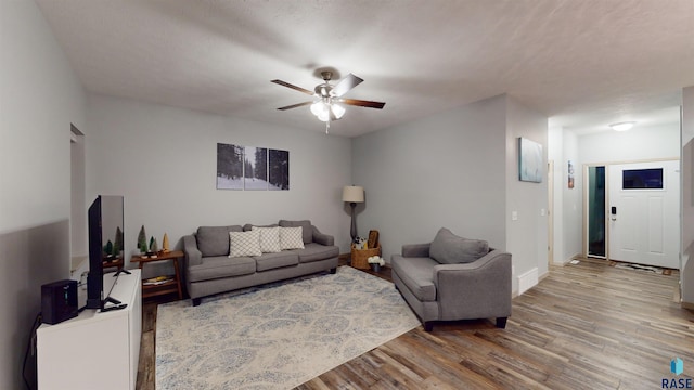 living room with hardwood / wood-style floors and ceiling fan