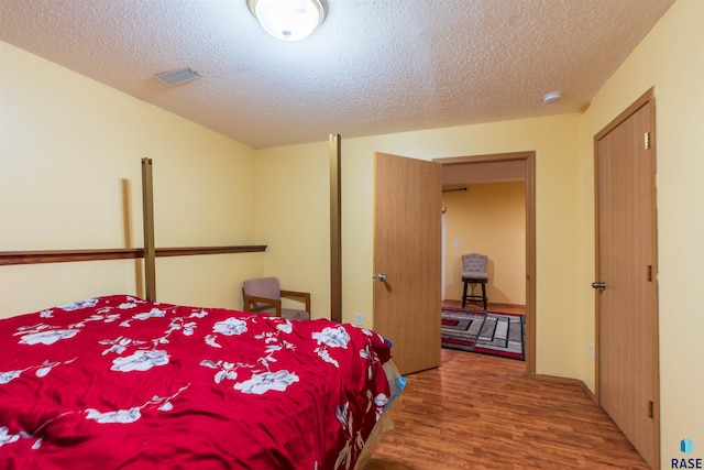 bedroom with wood-type flooring and a textured ceiling