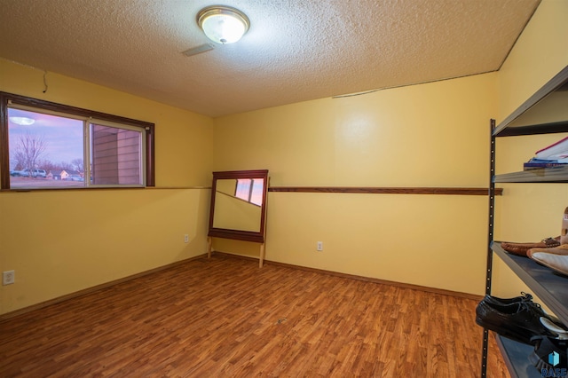 empty room featuring hardwood / wood-style floors and a textured ceiling