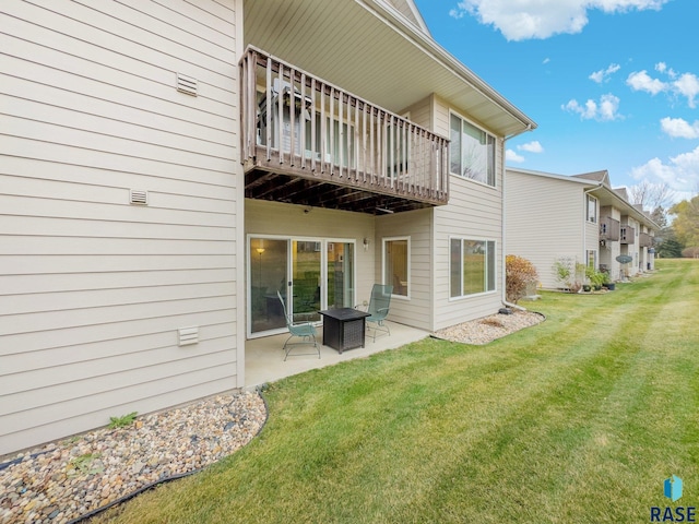 back of property with a yard and a patio