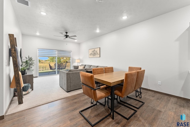 dining area with hardwood / wood-style floors, ceiling fan, and a textured ceiling