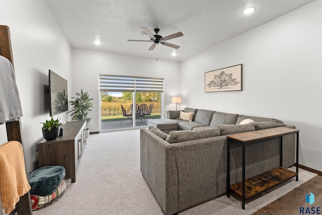 carpeted living room featuring ceiling fan