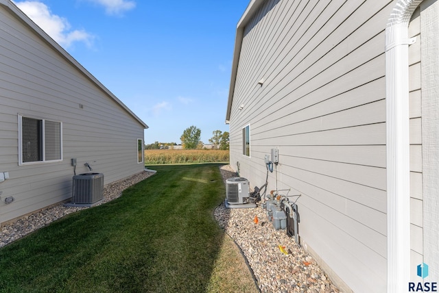 view of property exterior featuring a lawn and central air condition unit