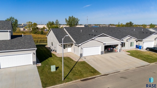 single story home featuring a garage and a front lawn