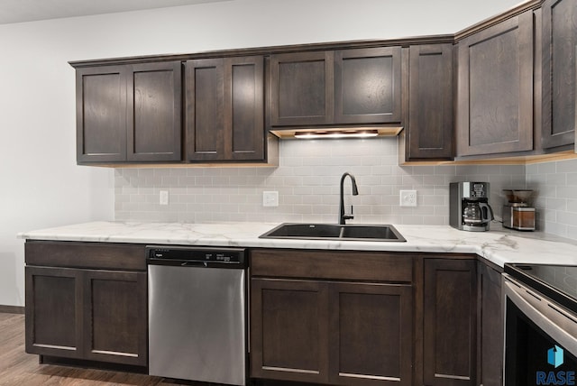 kitchen with dark brown cabinetry, dishwasher, sink, decorative backsplash, and hardwood / wood-style flooring