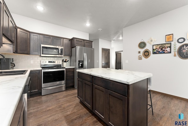 kitchen with a center island, dark wood-type flooring, sink, tasteful backsplash, and stainless steel appliances