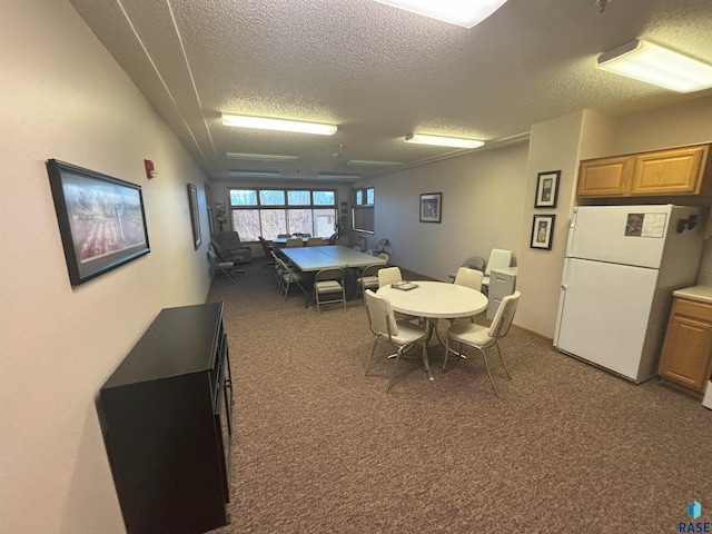 dining room featuring a textured ceiling and dark carpet