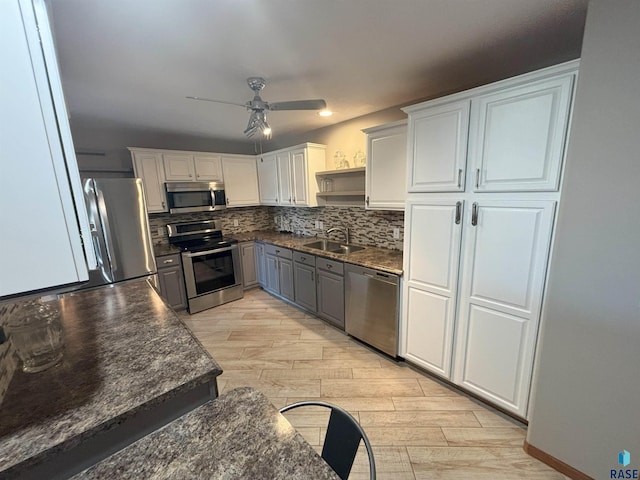 kitchen featuring light wood-type flooring, stainless steel appliances, ceiling fan, sink, and white cabinets