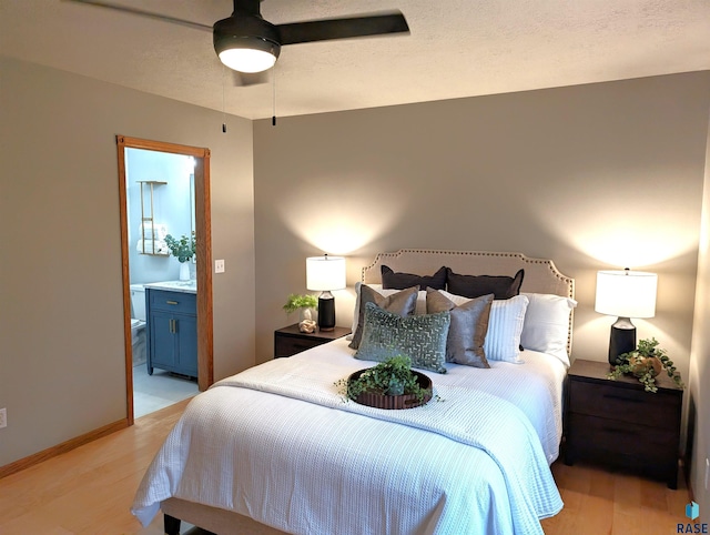 bedroom with ensuite bathroom, ceiling fan, and light wood-type flooring