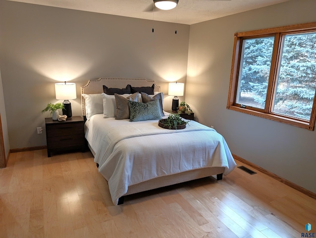 bedroom with ceiling fan and light hardwood / wood-style flooring