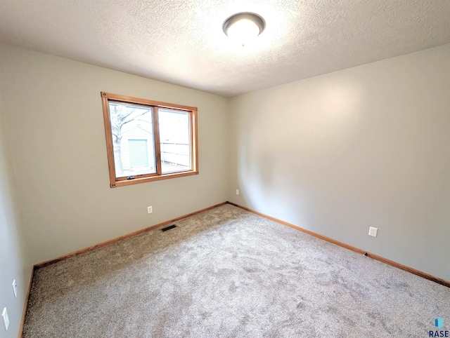 empty room with carpet flooring and a textured ceiling