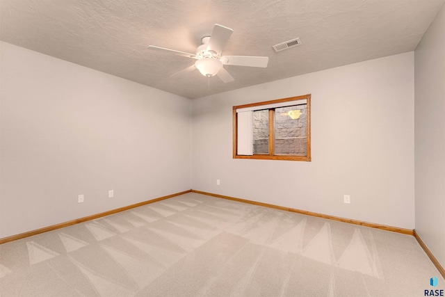 spare room featuring a textured ceiling, carpet floors, and ceiling fan