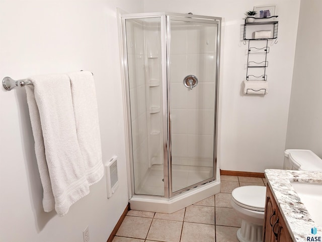 bathroom with tile patterned flooring, vanity, toilet, and walk in shower