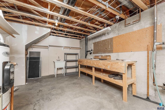 basement with a workshop area, gas water heater, and sink