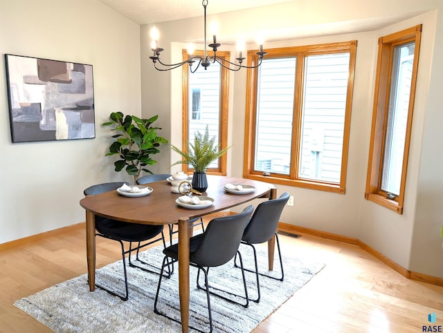 dining room with a chandelier and light hardwood / wood-style flooring