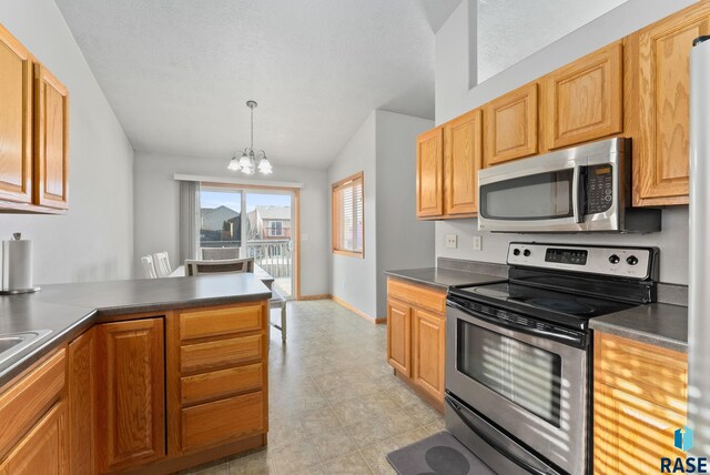 kitchen featuring decorative light fixtures, stainless steel appliances, and a chandelier