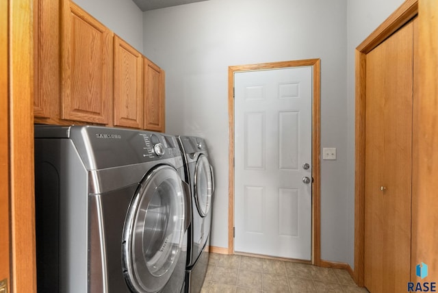 laundry room featuring washer and dryer and cabinets