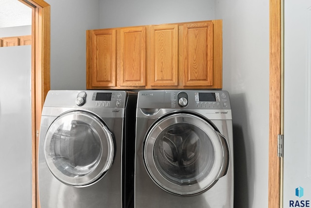 washroom with cabinets and washing machine and dryer