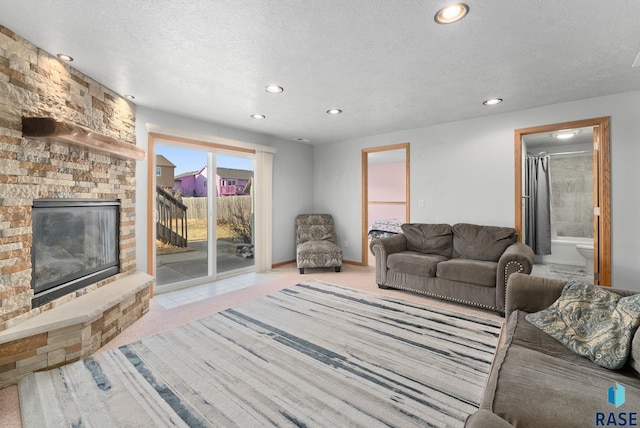 carpeted living room with a textured ceiling and a fireplace