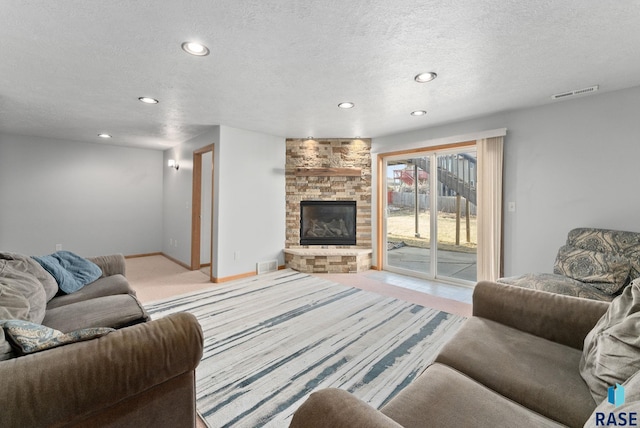 living room with light carpet, a fireplace, and a textured ceiling