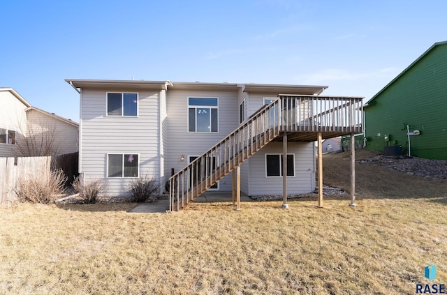 rear view of property featuring a lawn, central air condition unit, and a deck