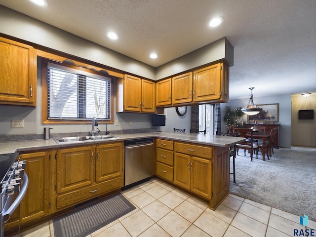 kitchen with sink, stainless steel appliances, kitchen peninsula, decorative light fixtures, and light carpet